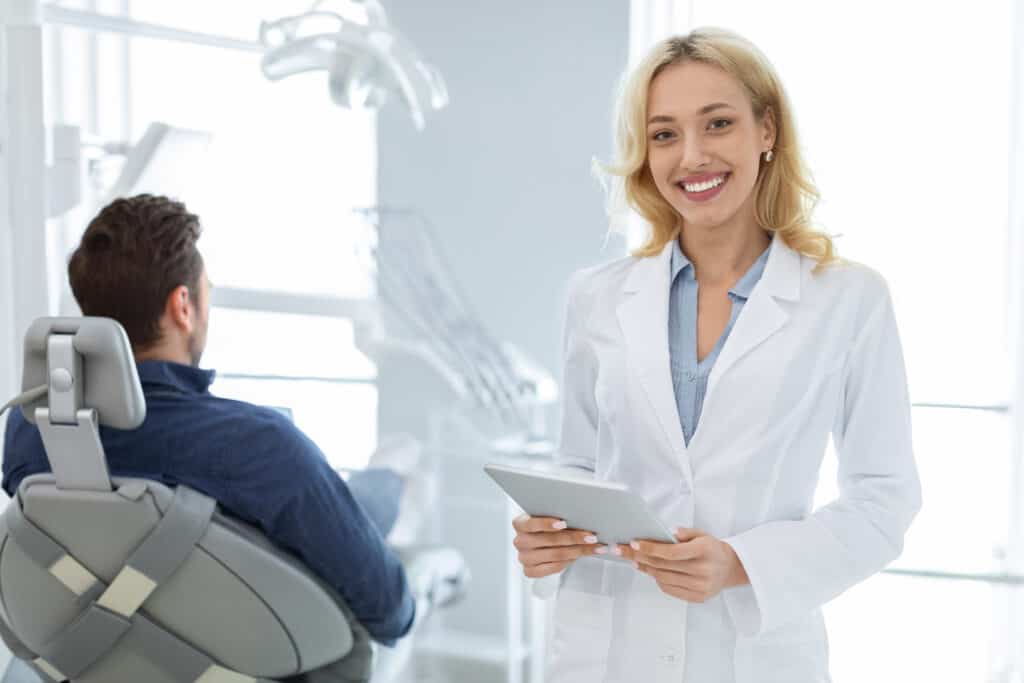 cheerful woman dentist with digital tablet smiling EKB6VFK