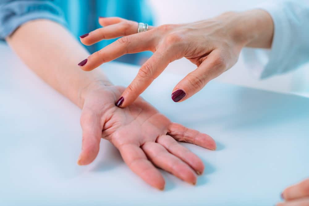 examining the hand of a senior patient with carpal HPBQQL5