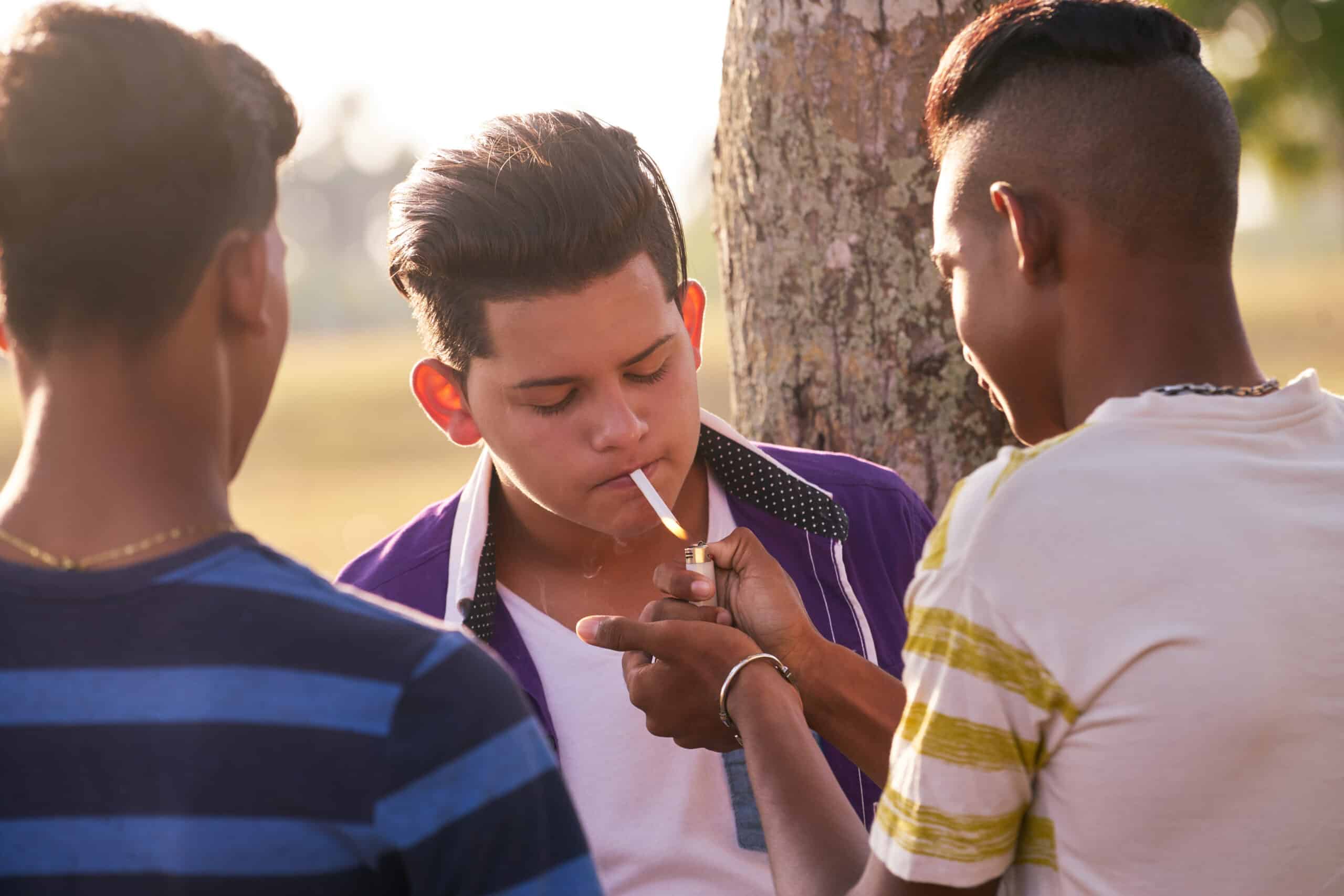 group of teenagers boy smoking cigarette with frie PULUS6X scaled