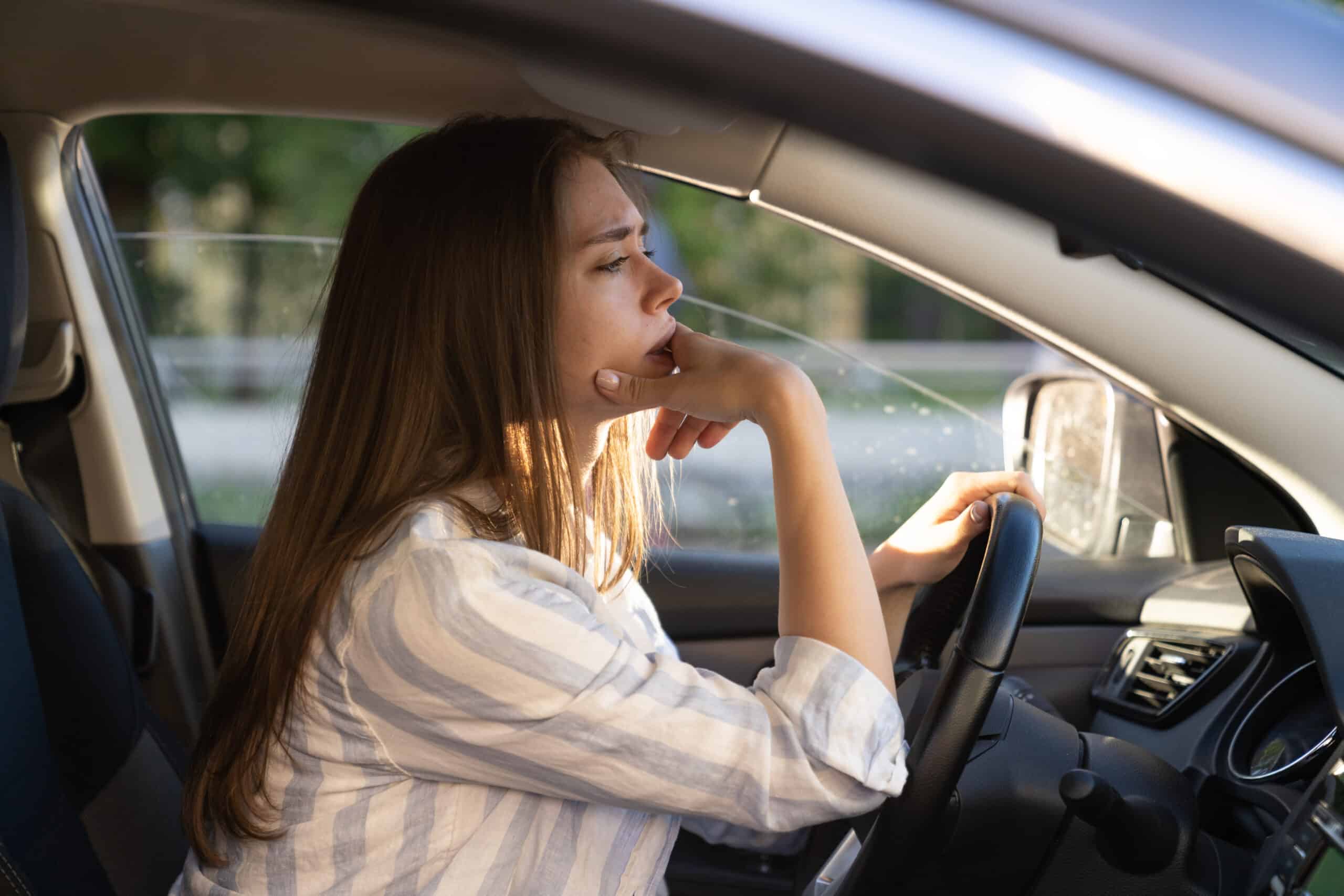 sad tired young woman driving car unhappy girl dri V93L93H scaled